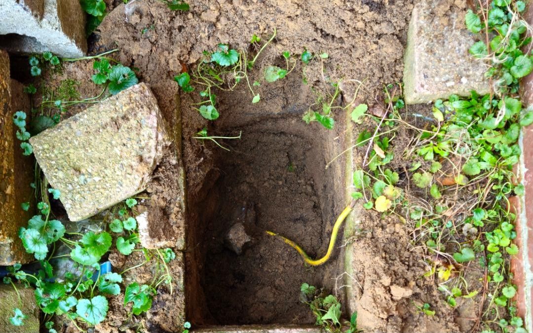 Uitgegraven put naast een gevel met een geelgroene aardingsgeleider