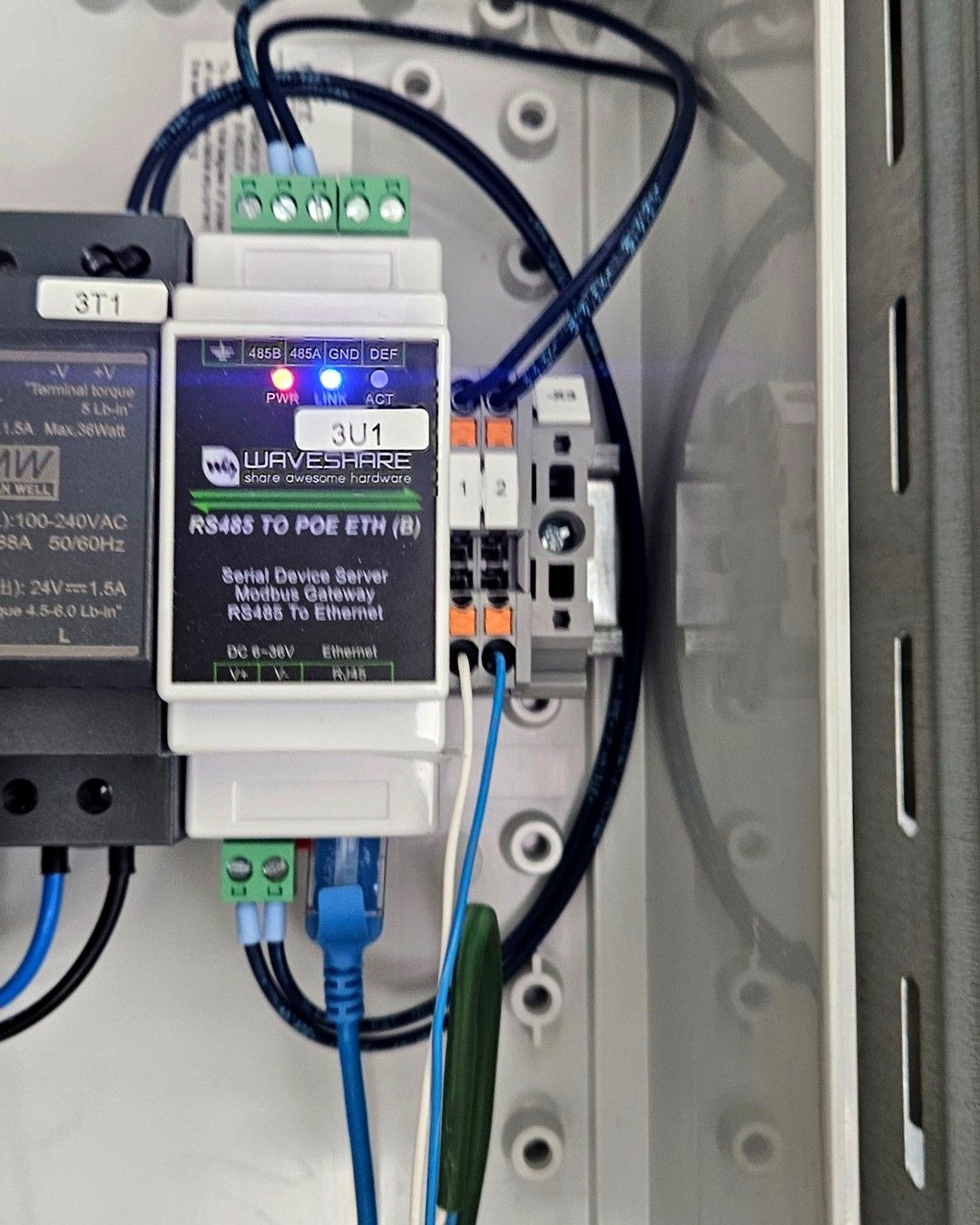 Close-up van een RS485-naar-ethernetomvormer op DIN-rail met netwerkkabel