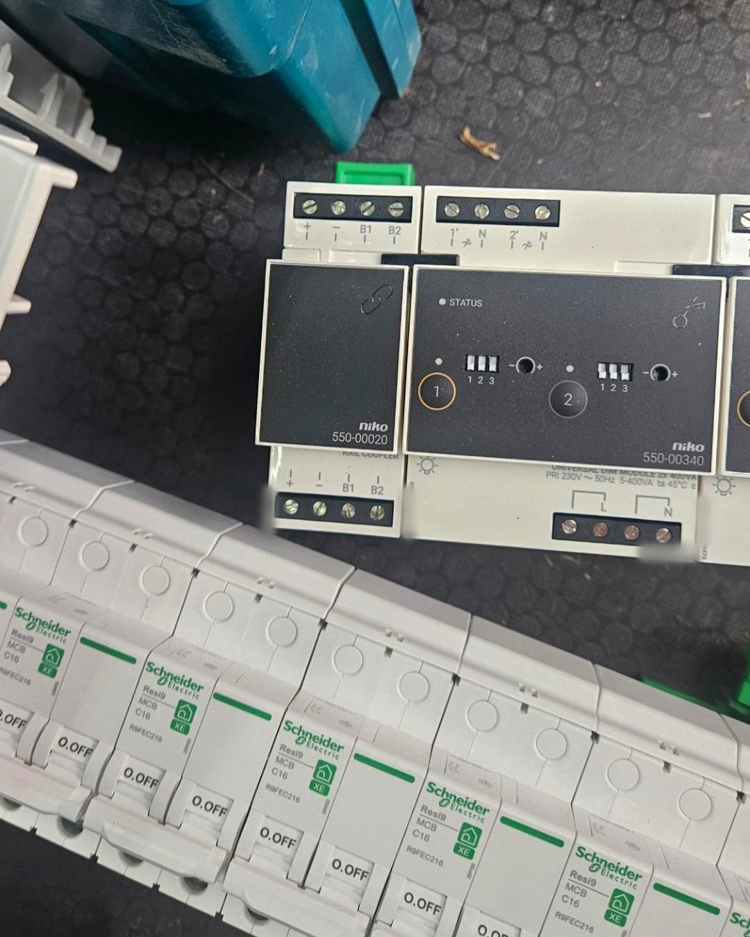 Modules van Niko Home Control en een rij witte automaten op een werkmat